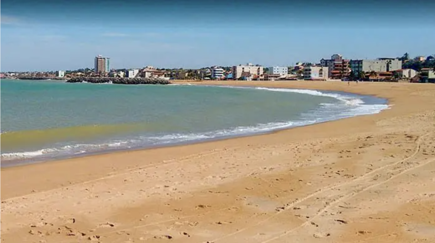 Praia da Cruz em Marataízes — areia dourada e pedras no litoral sul do ES